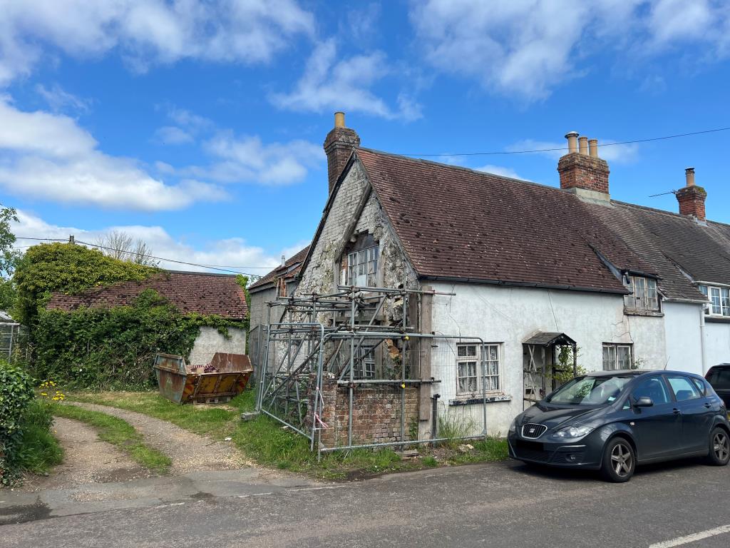 Lot: 128 - THREE-BEDROOM COTTAGE FOR IMPROVEMENT IN POPULAR VILLAGE LOCATION - Front of the cottage